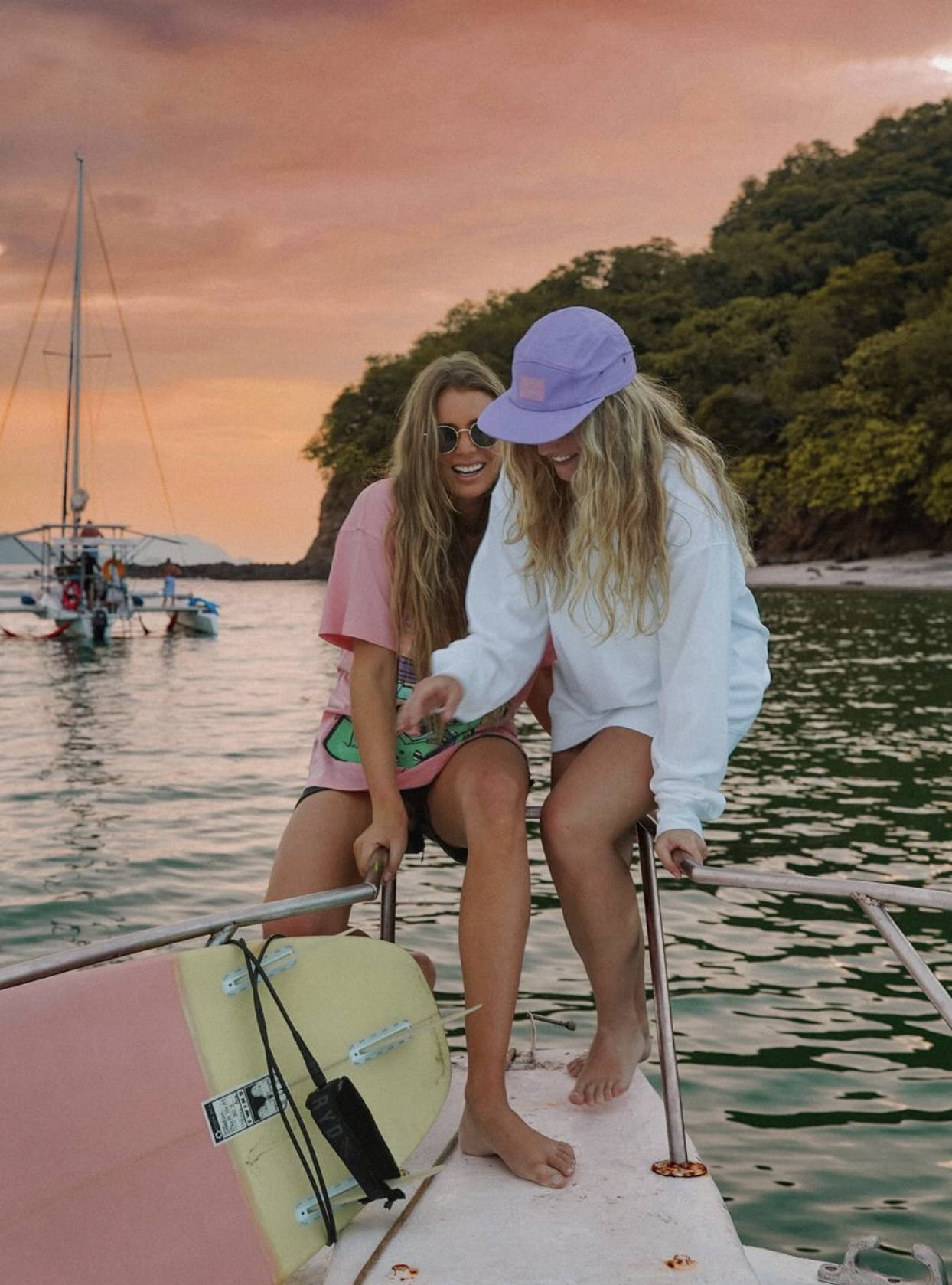Two female friends on a boat at sunset