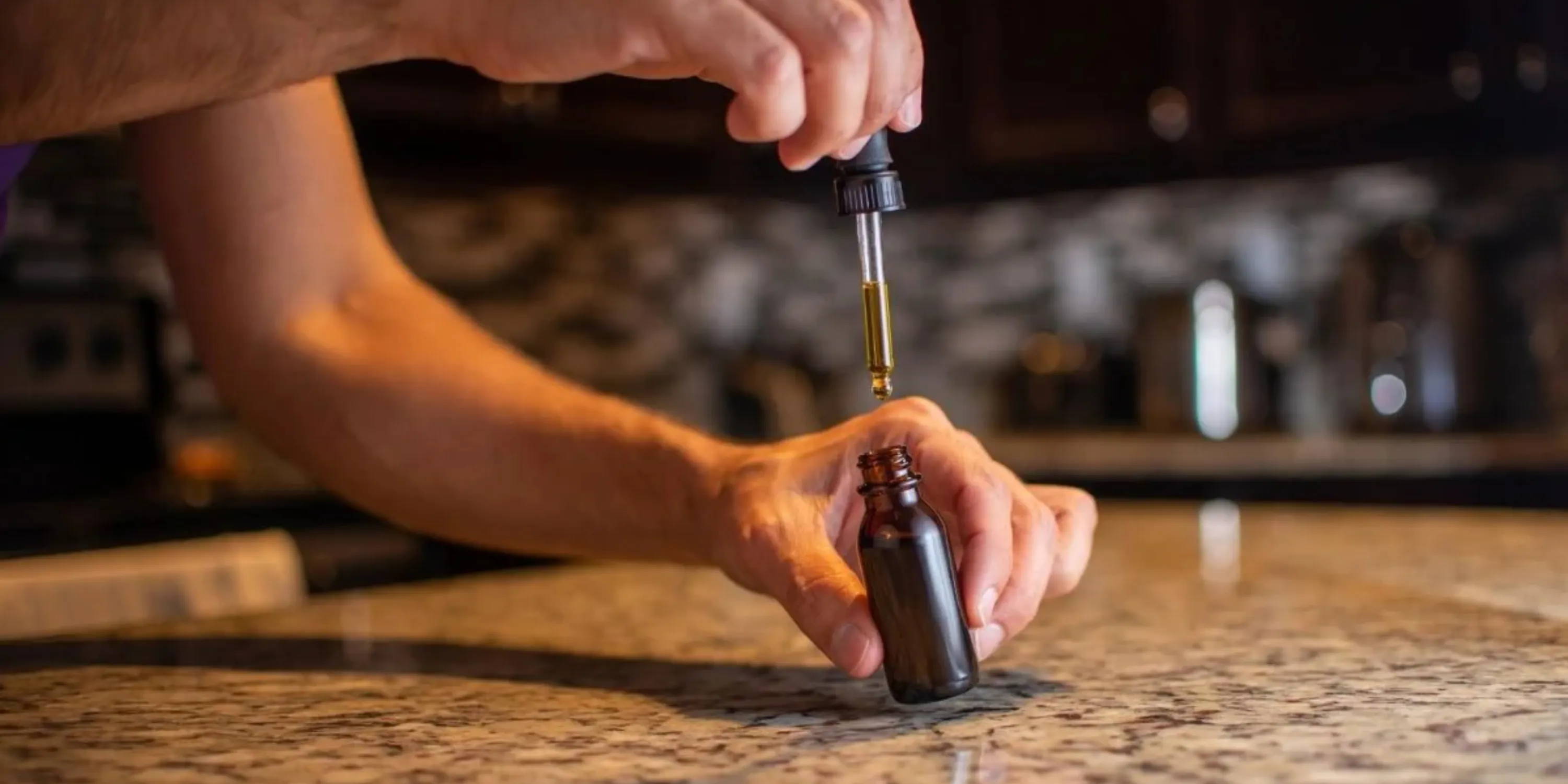A person uses a dropper bottle for mushroom tincture