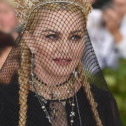 Woman in elaborate crown and black veil at a formal event.