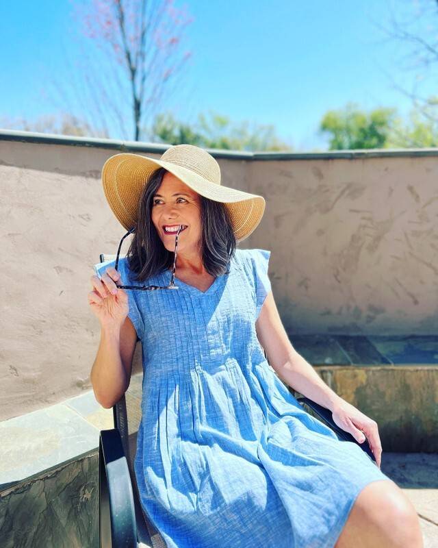 Nicole wearing the Devon dress outside on a patio.