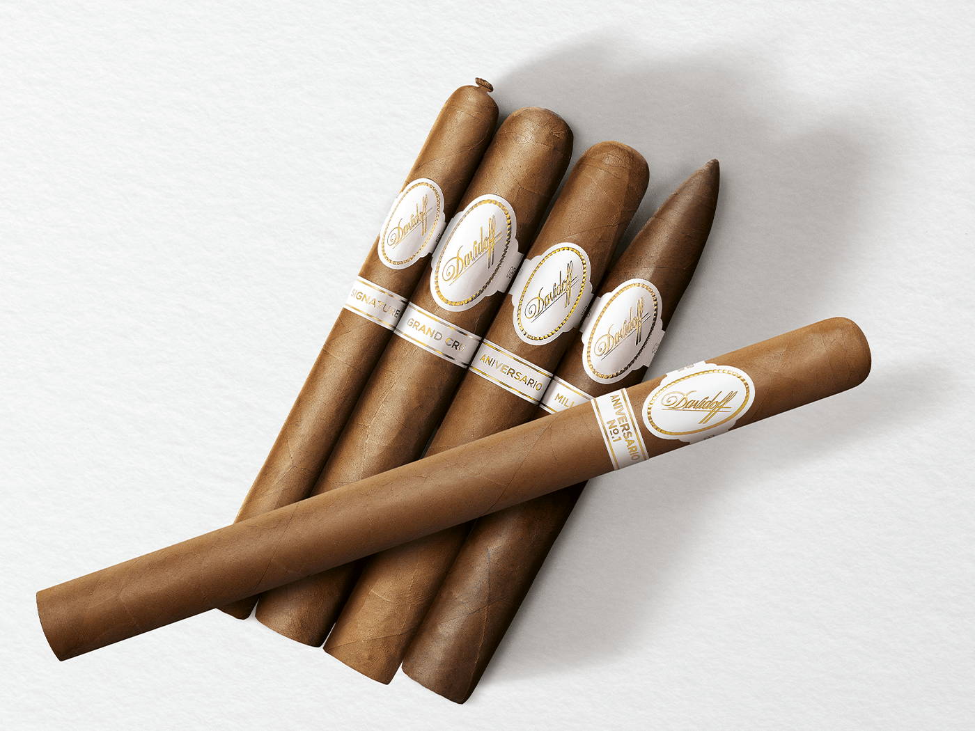 4 Zigarren der Davidoff White Band Collection Linien Signature, Grand Cru, Millennium und Aniversario mit einer Davidoff Aniversario No. 1 Limited Edition Collection Zigarre quer drüberliegend. 