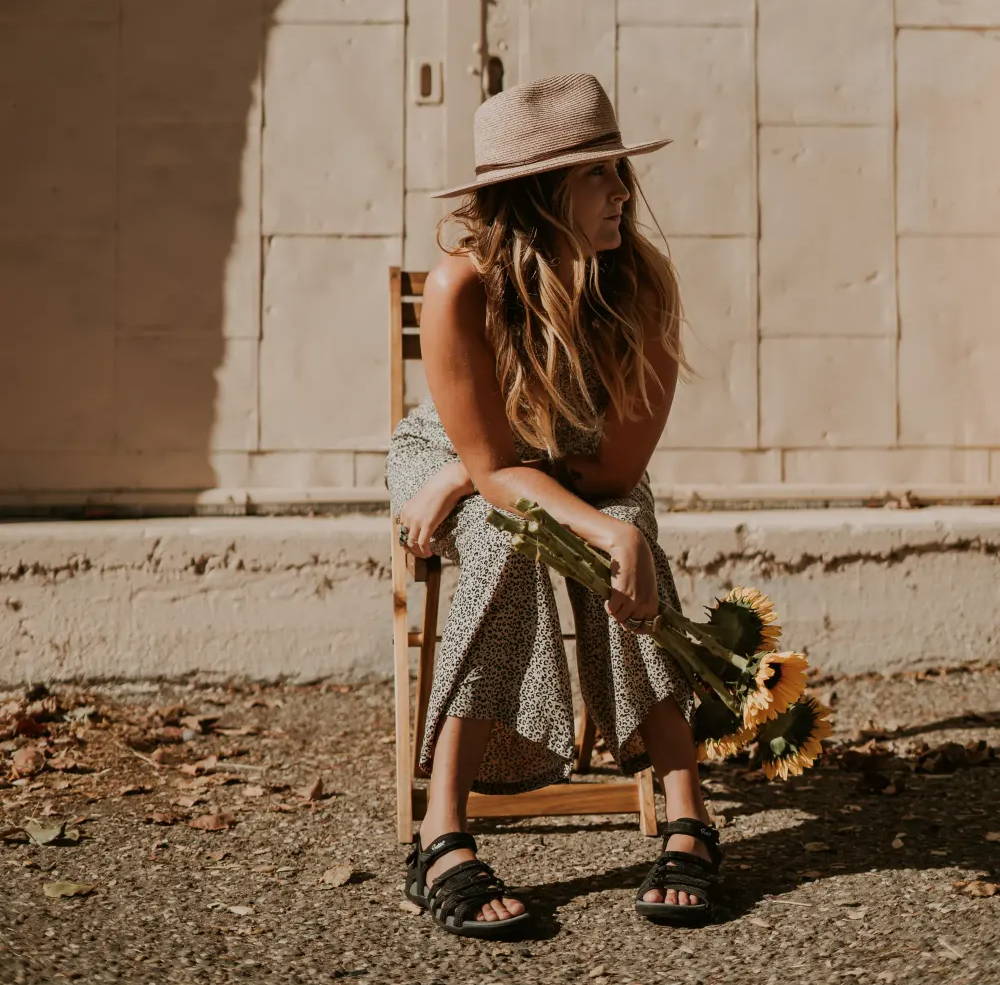 woman sitting in chair with wide sandals