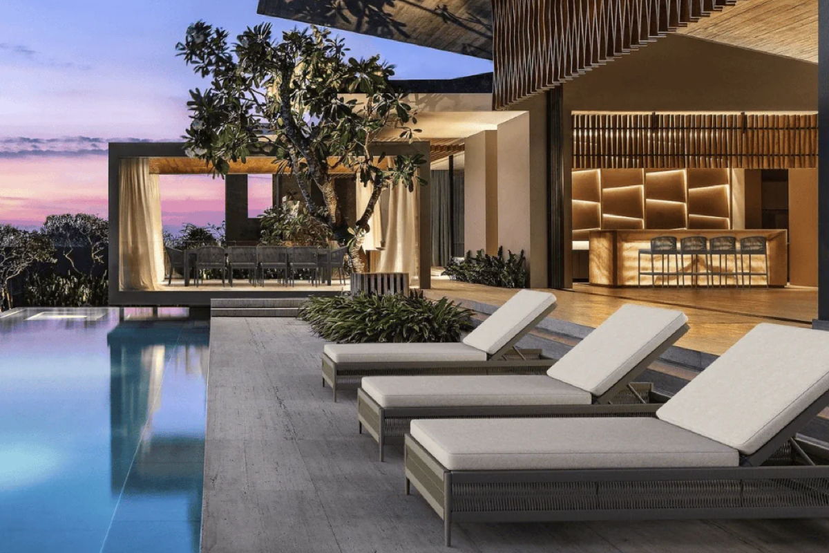Modern poolside patio with chaise lounges, outdoor bar seating, and a covered dining area arranged for entertaining after sunset.