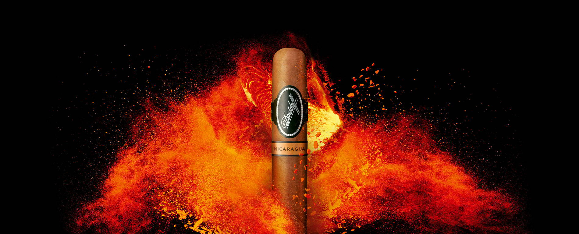 Eine Davidoff Nicaragua-Zigarre, die vor einem mächtigen und leuchtend orangefarbenem Feuer steht.