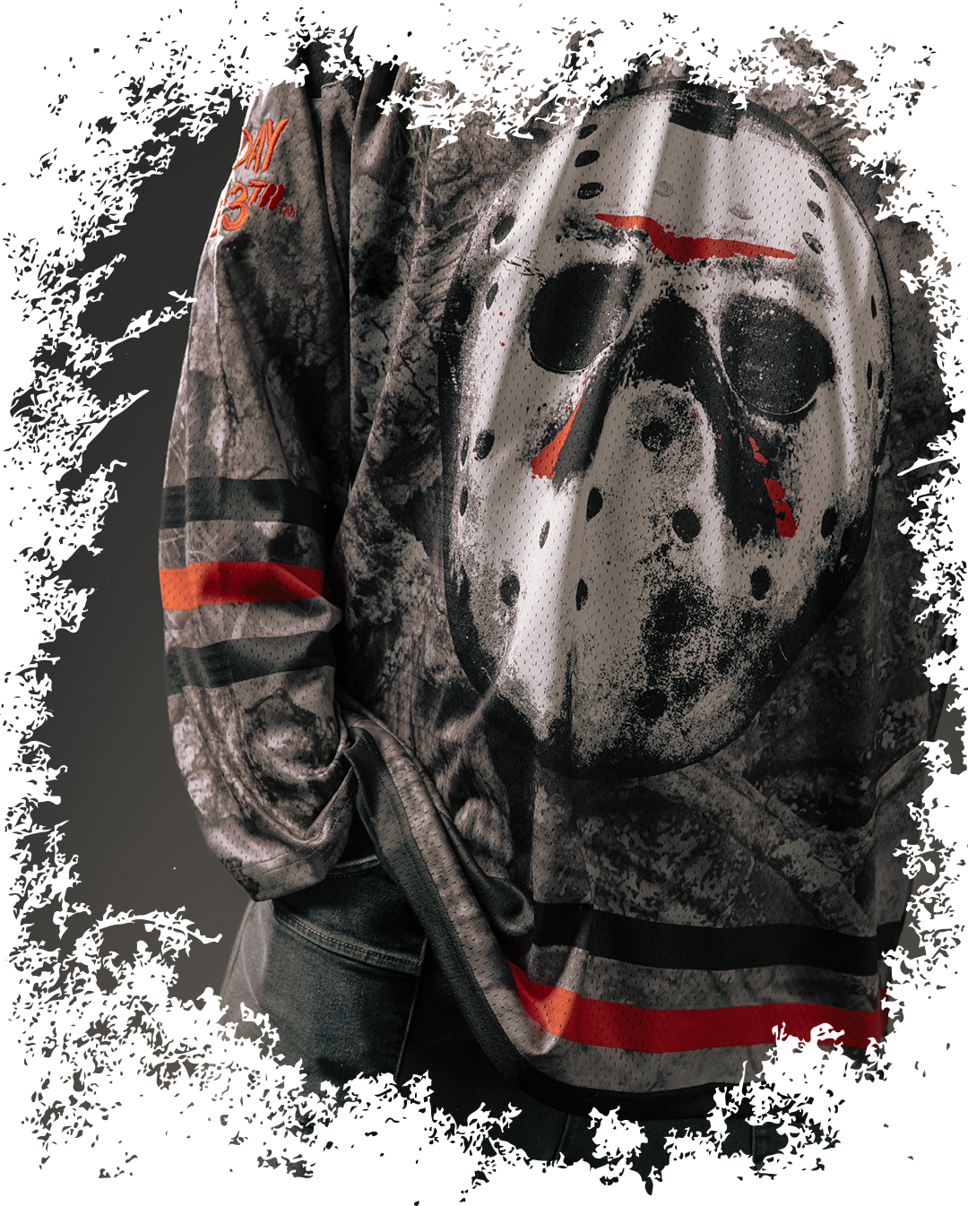 A shirt featuring a mask design and dark, textured background.