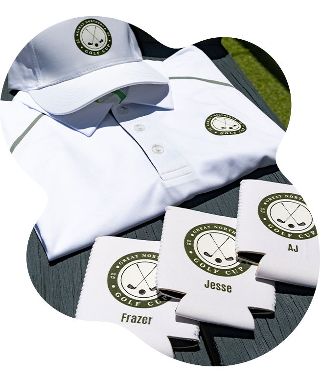 White Great Northern Golf Cup polo shirt and white structured cap, both printed with the circular crossed-clubs logo, displayed on an outdoor wooden surface alongside personalised white stubby holders labelled with names Frazer, Jesse, and AJ
