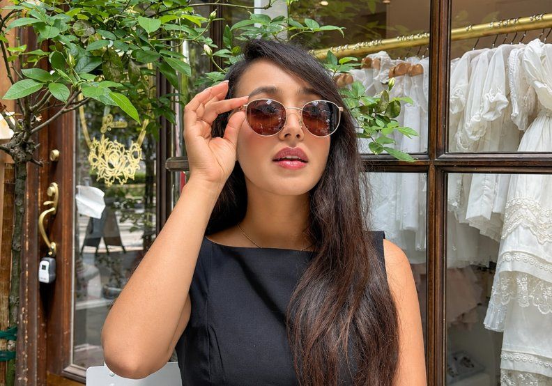 woman with round face wearing round metal sunglasses 