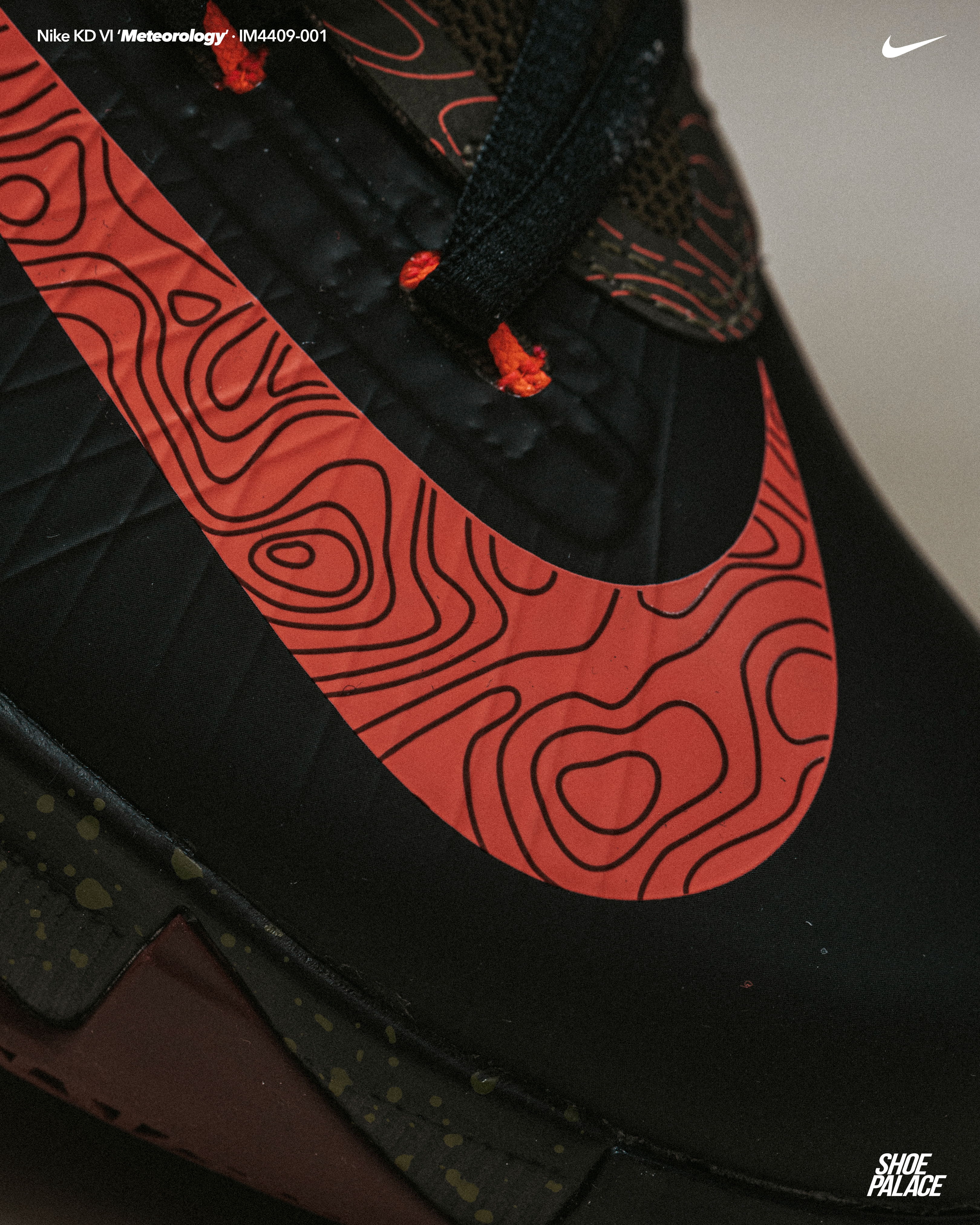 Close-up of black Nike shoe with red patterned logo.