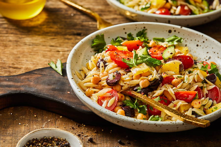Orzo pasta salad with fresh vegatables, chickpeas, olives and more