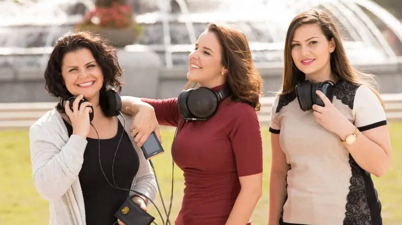 Three female models enjoying a beautiful day outside with their high-end audiophile-grade headphones.  