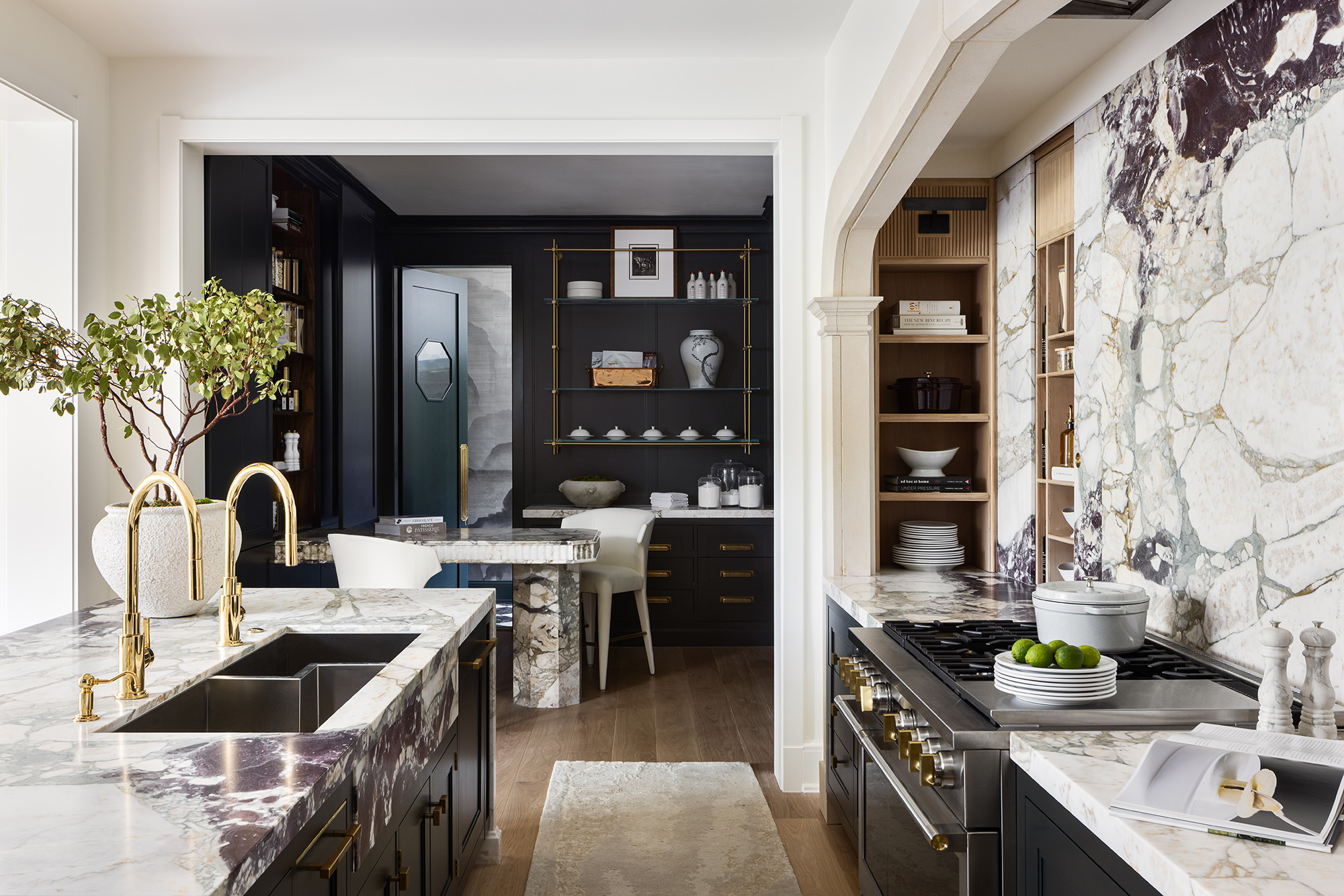 Navy kitchen design by McCroskey Interiors with brass hardware, marble worktops and wood flooring