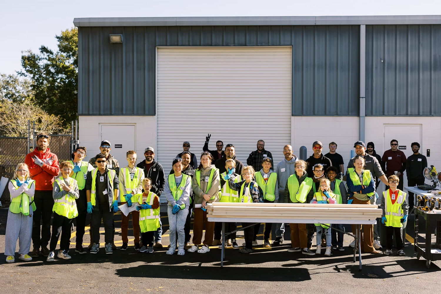 A group of people in vests posing in front of a building.
