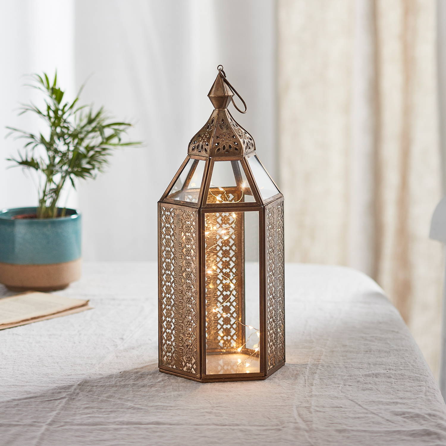 Artisan Moroccan lantern with illuminated micro lights within in and displayed on table