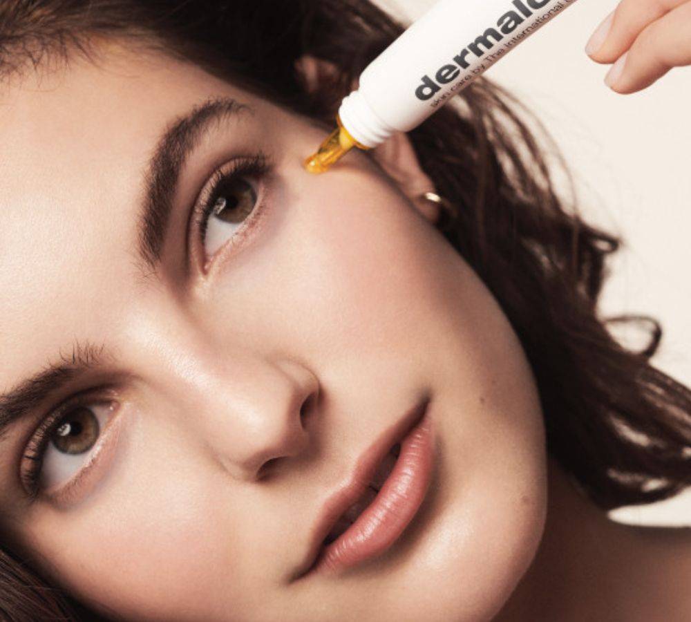 Woman applying eye cream on eye area