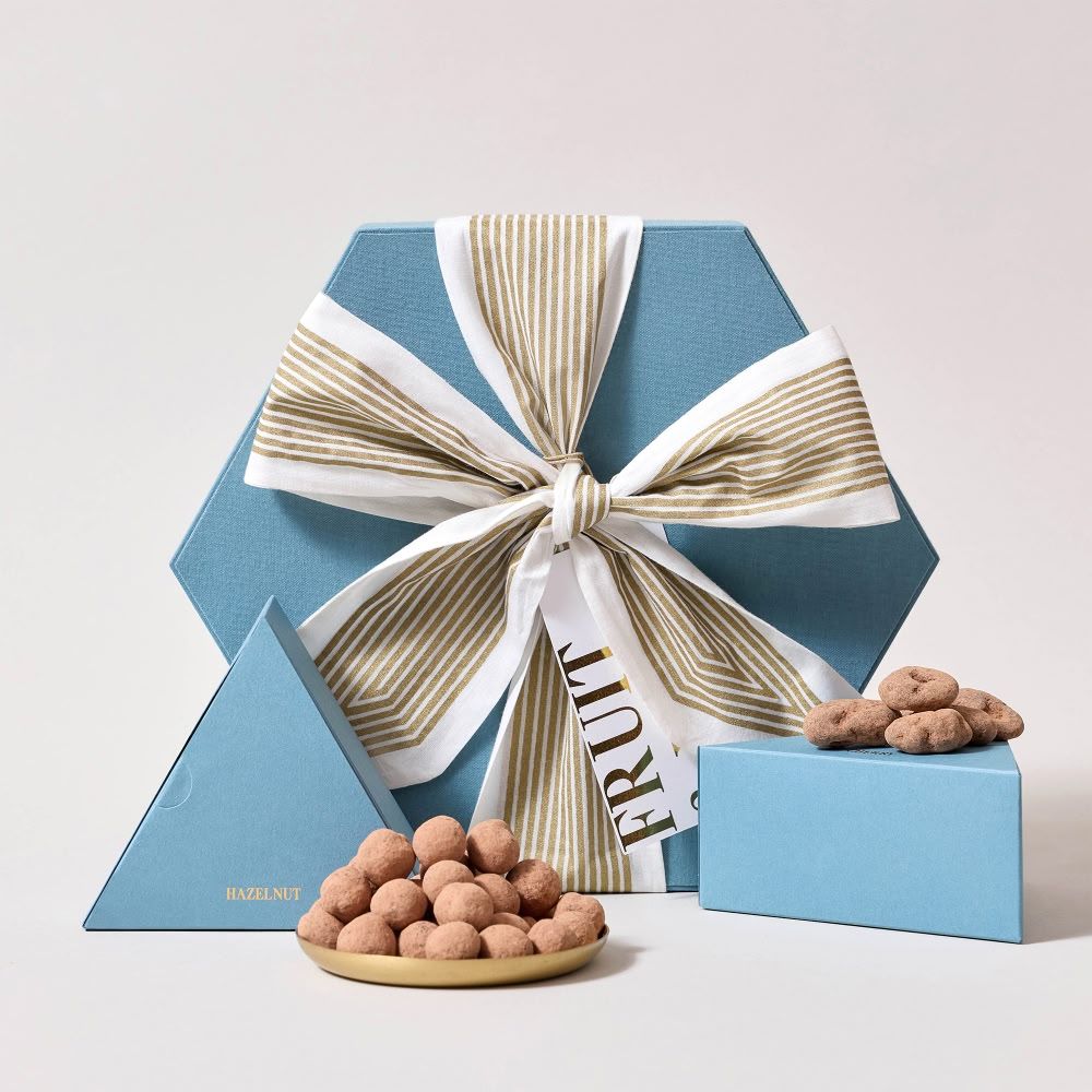 Gift boxes in blue with a ribbon and chocolate-covered almonds.