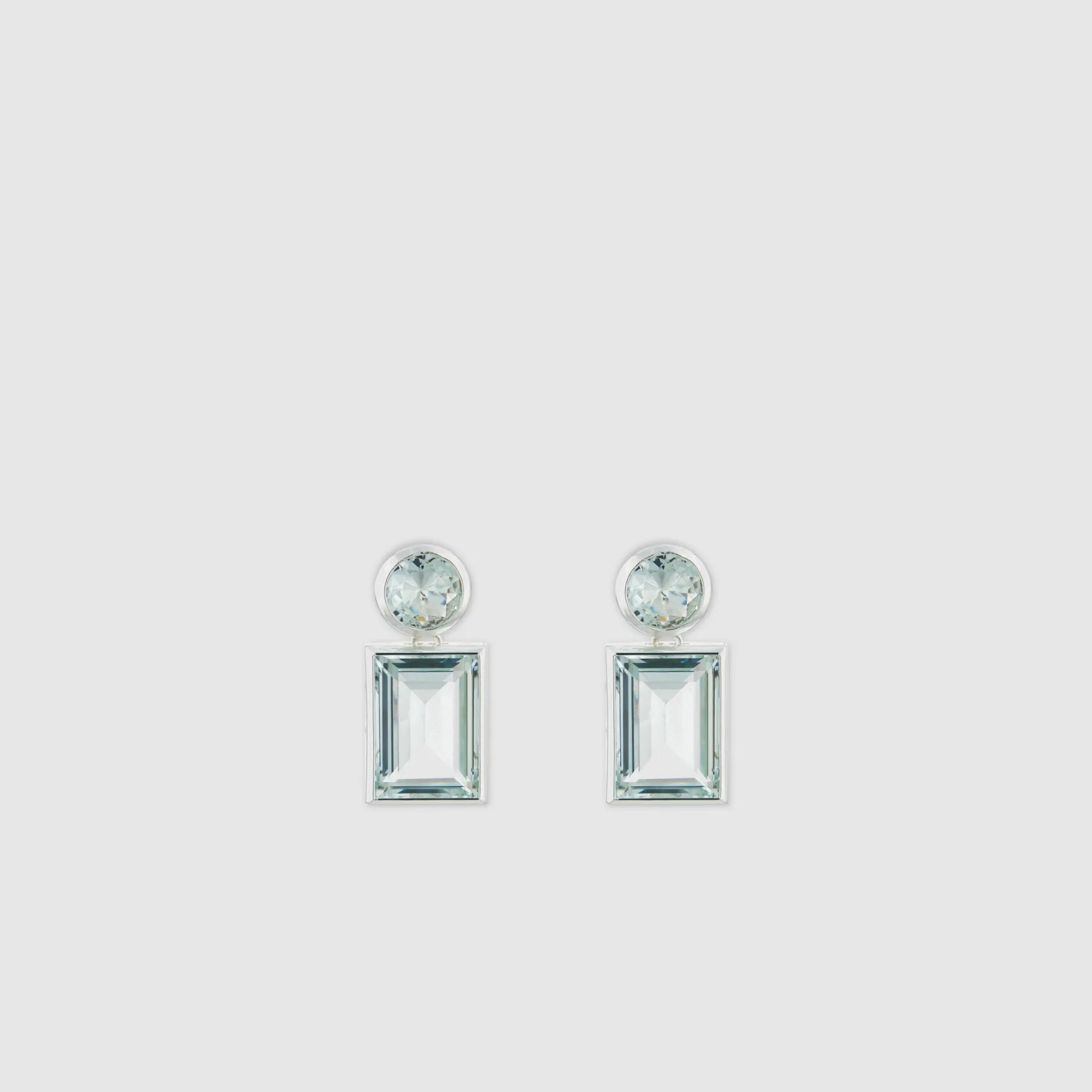 A pair of elegant gemstone earrings with rectangular and round shapes.