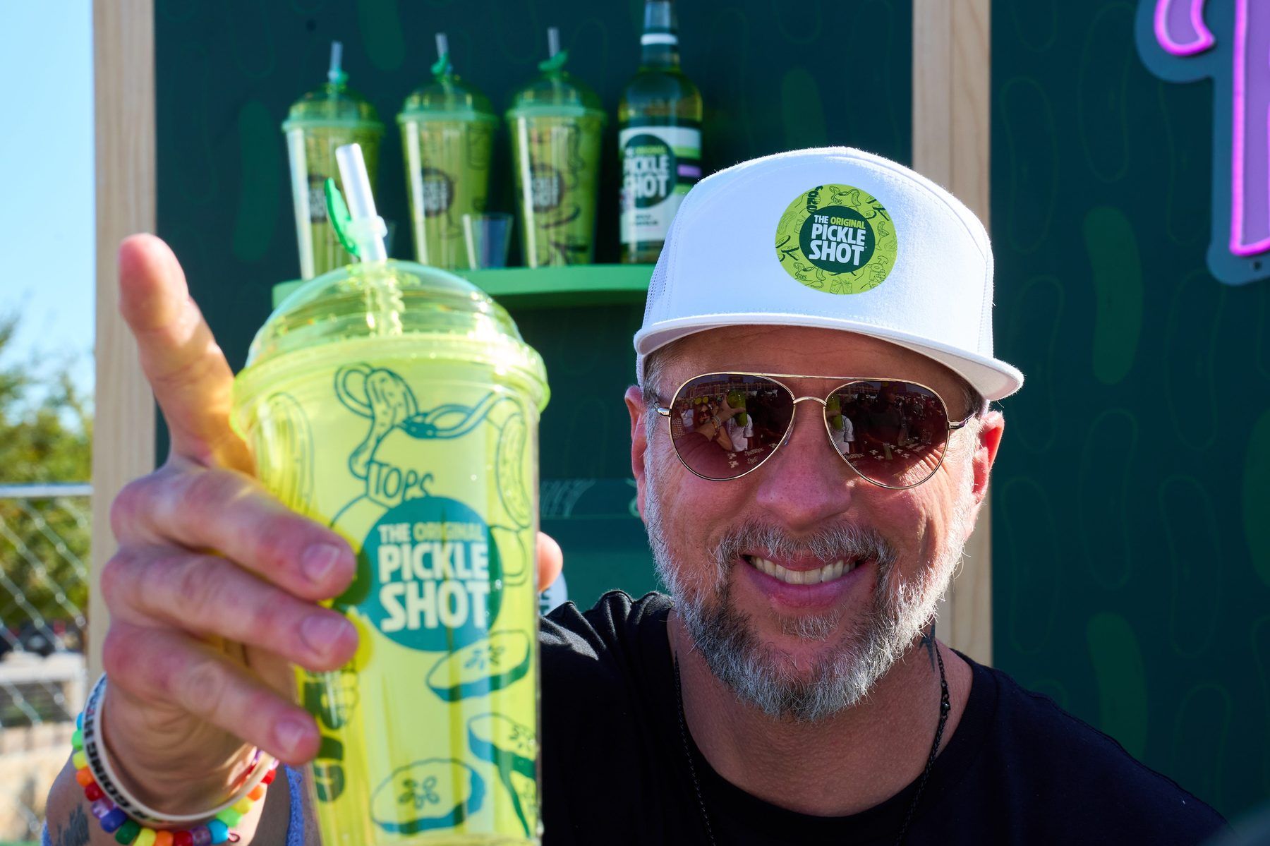 Guest holding a souvenir cup of The Original Pickle Shot at The Big Dill Arlington Texas 2025.