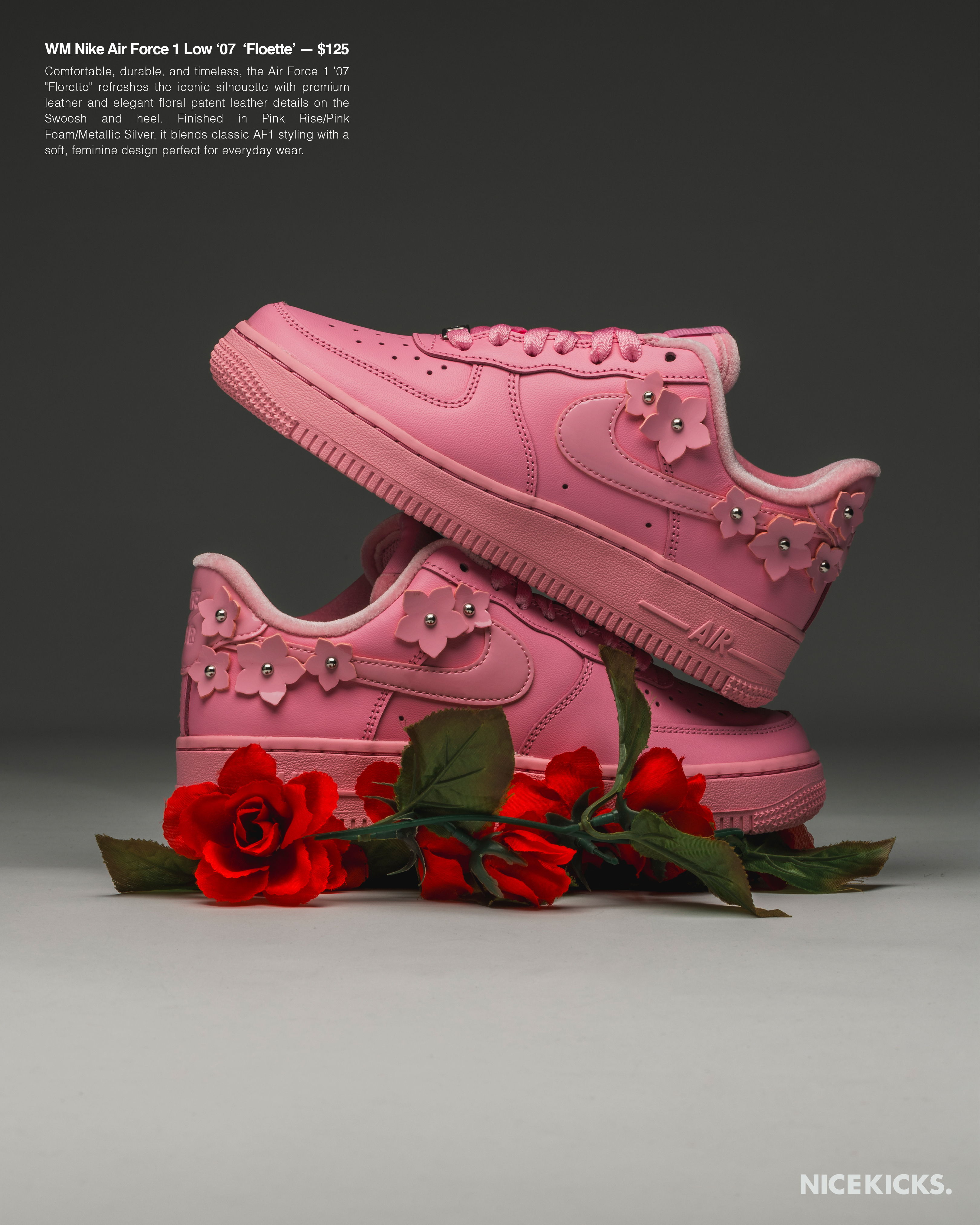Pink sneakers with floral design, placed on roses against a dark background.