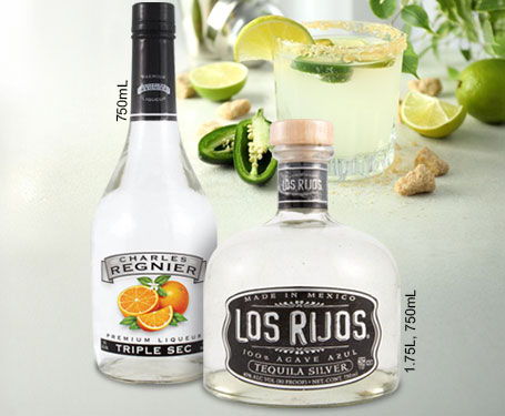 Bottles of tequila with limes and a cocktail in the background.