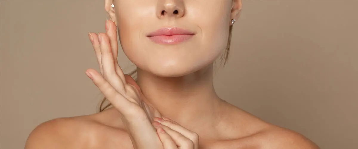 Woman touching hydrated, plump skin, illustrating collagen support for skin elasticity.