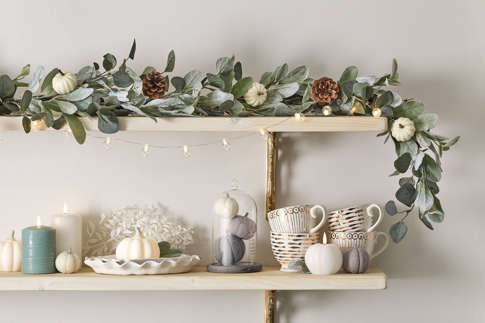 Autumnal wall shelf with pumpkins, LED candles and garland