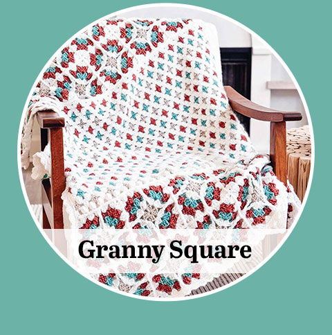 A colorful granny square blanket draped over a wooden chair, with the words 