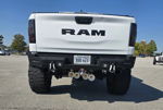 Rear view of white RAM 1500 Rebel with aftermarket bumper and four train horns mounted below