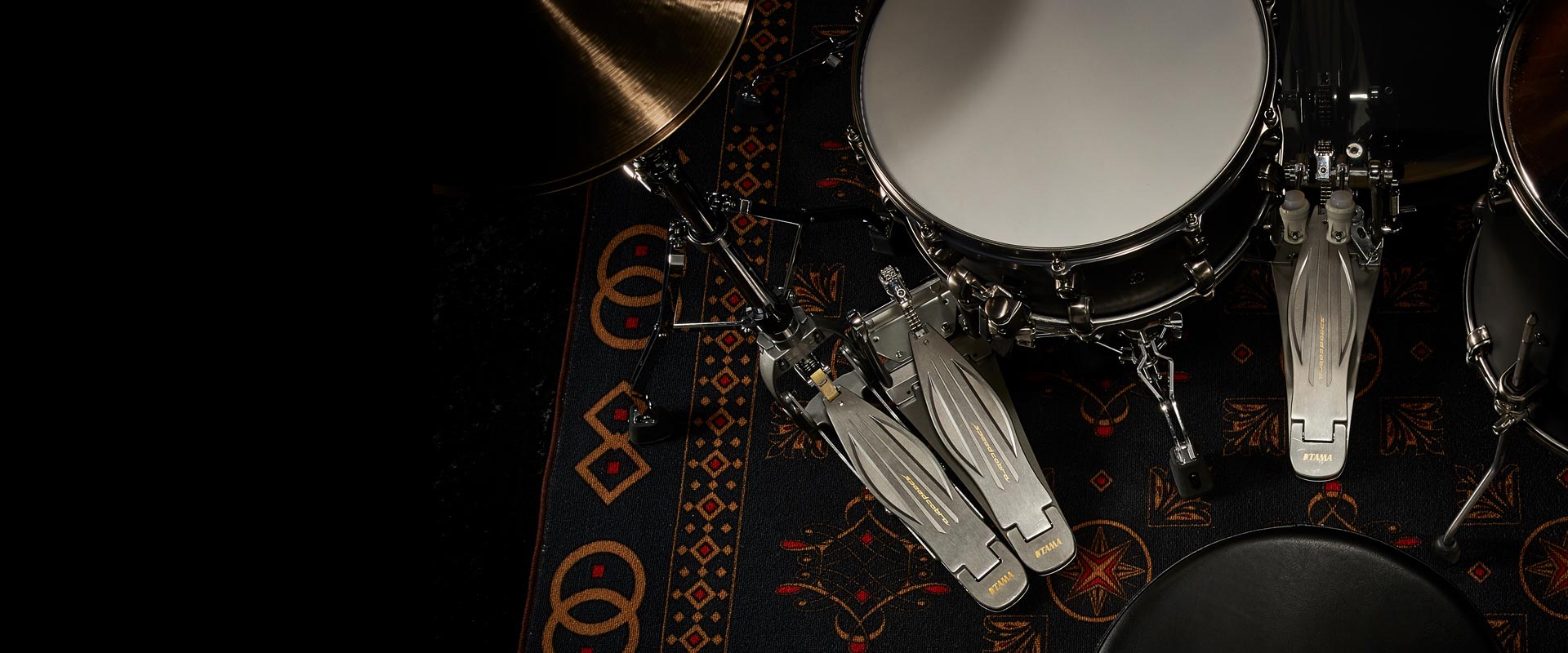 Drum set on a patterned rug with a microphone.