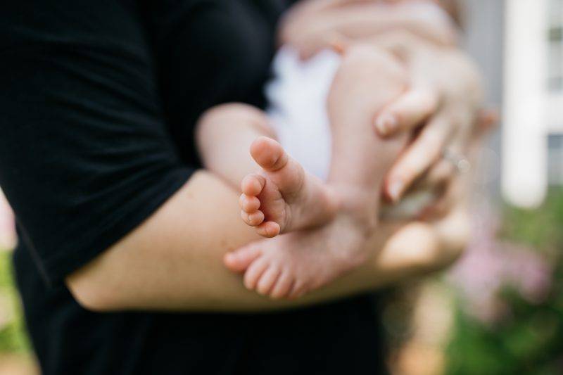 Person Holding Baby In Arms