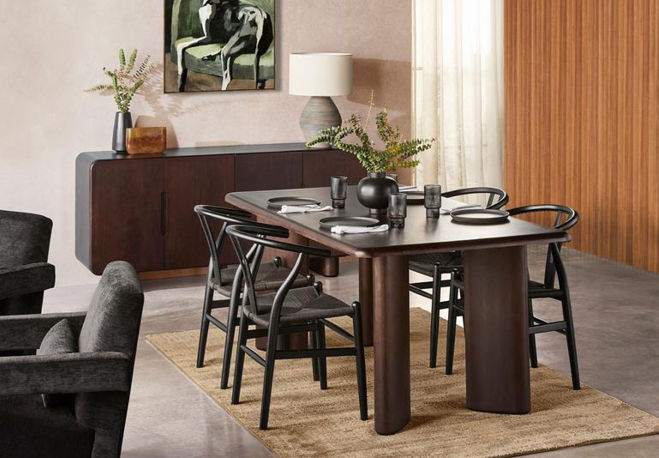 Dining room with table, chairs, and decorative elements on a rug.