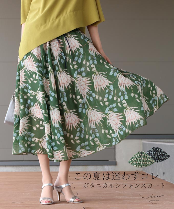 A woman twirling in a green floral skirt and yellow top.