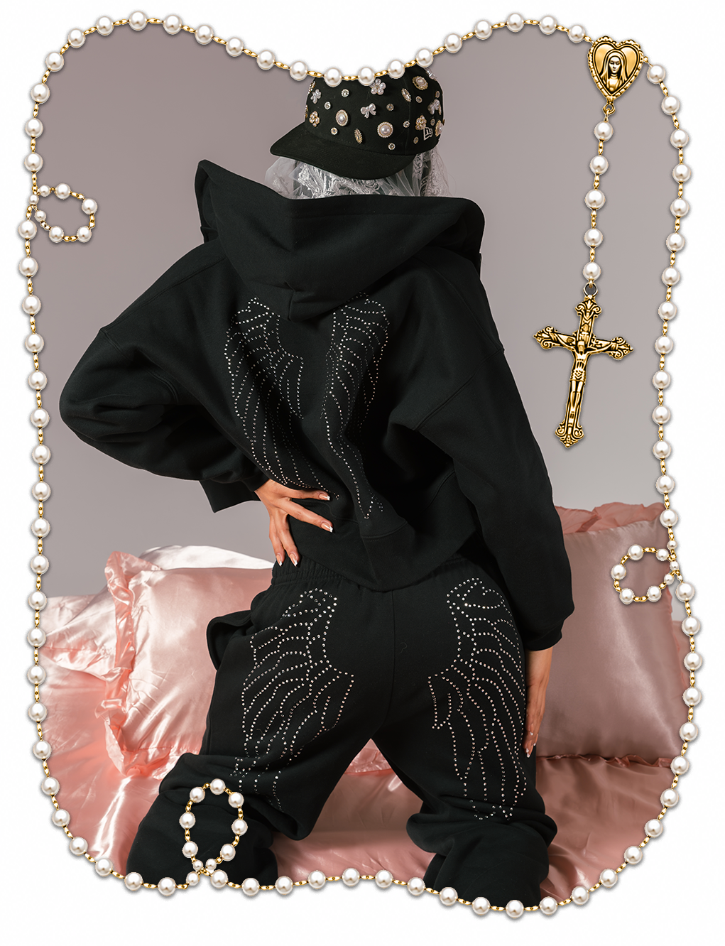 Person wearing a black hoodie and pants with decorative wings design.