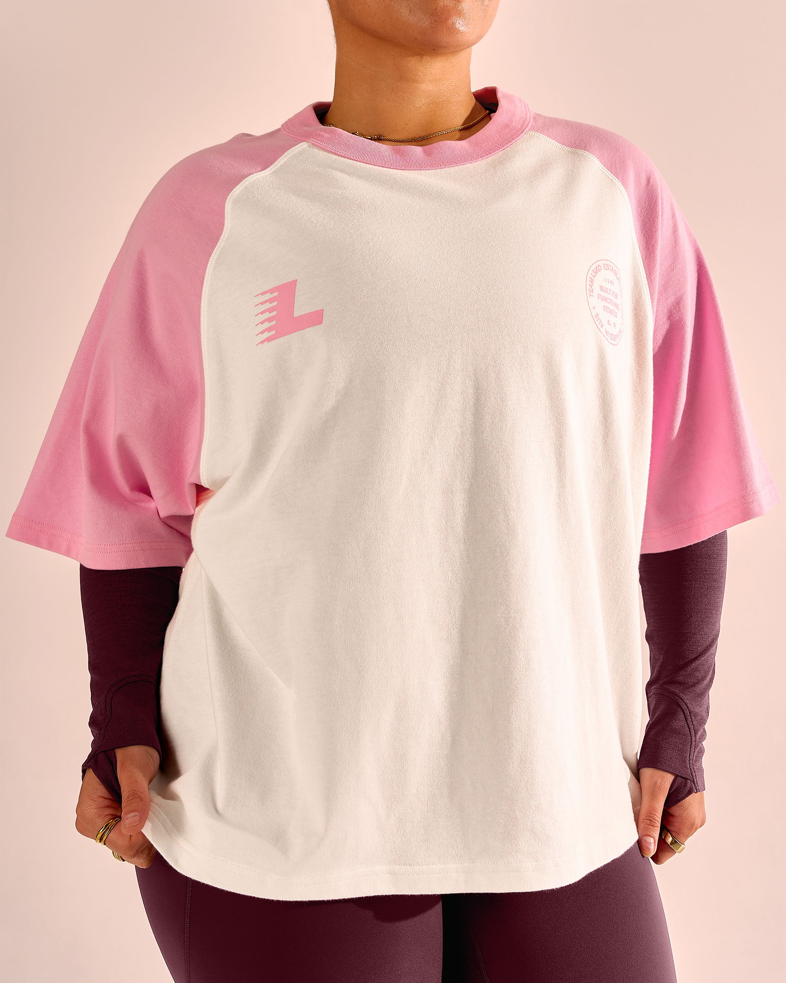 Person wearing a pink and white oversized t-shirt.