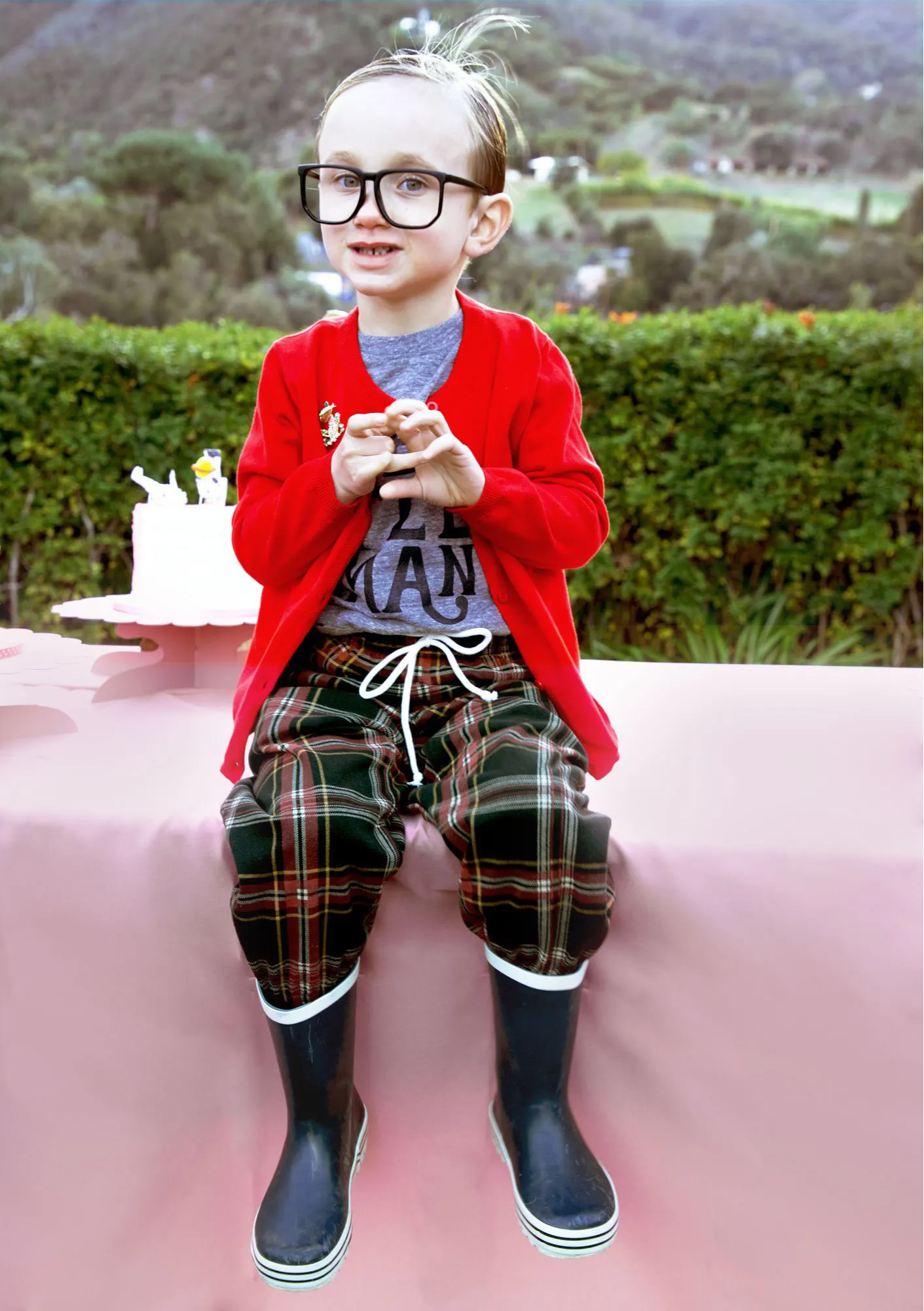 child sitting down wearing rain boots