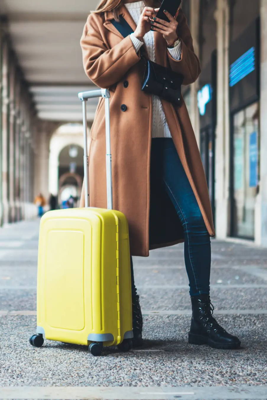Woman on phone traveling with suitcase