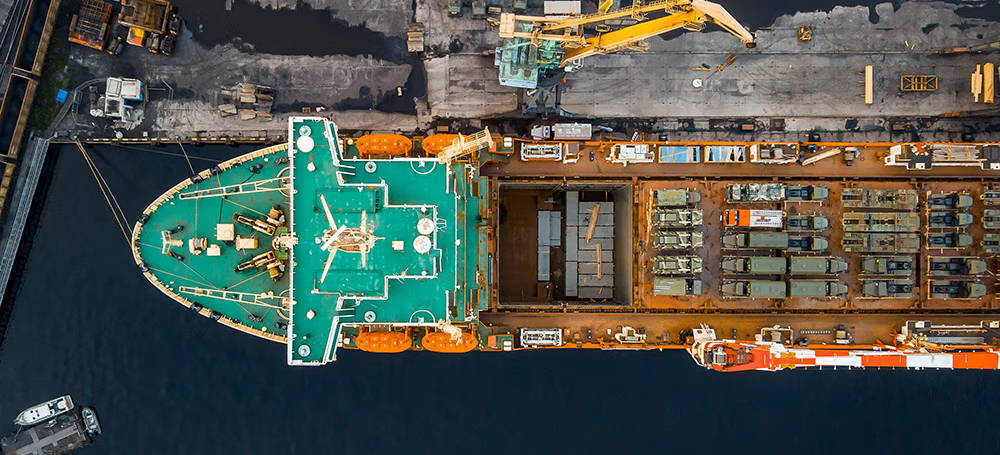 Aerial view of cargo ship transporting equipment within defense supply chains