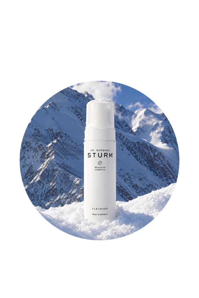 Skincare product against a snowy mountain backdrop in a circular frame.