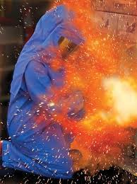 Person in blue hoodie surrounded by an explosion of orange sparks.