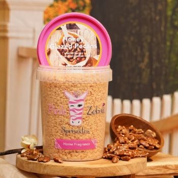 Container of powdered sugar with a scoop and nuts beside it.