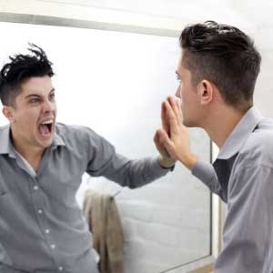 A man yelling at himself in the mirror