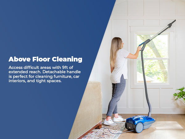 Person using a vacuum cleaner to reach high areas for cleaning.