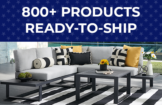 Modern outdoor furniture with decorative pillows on a striped rug.