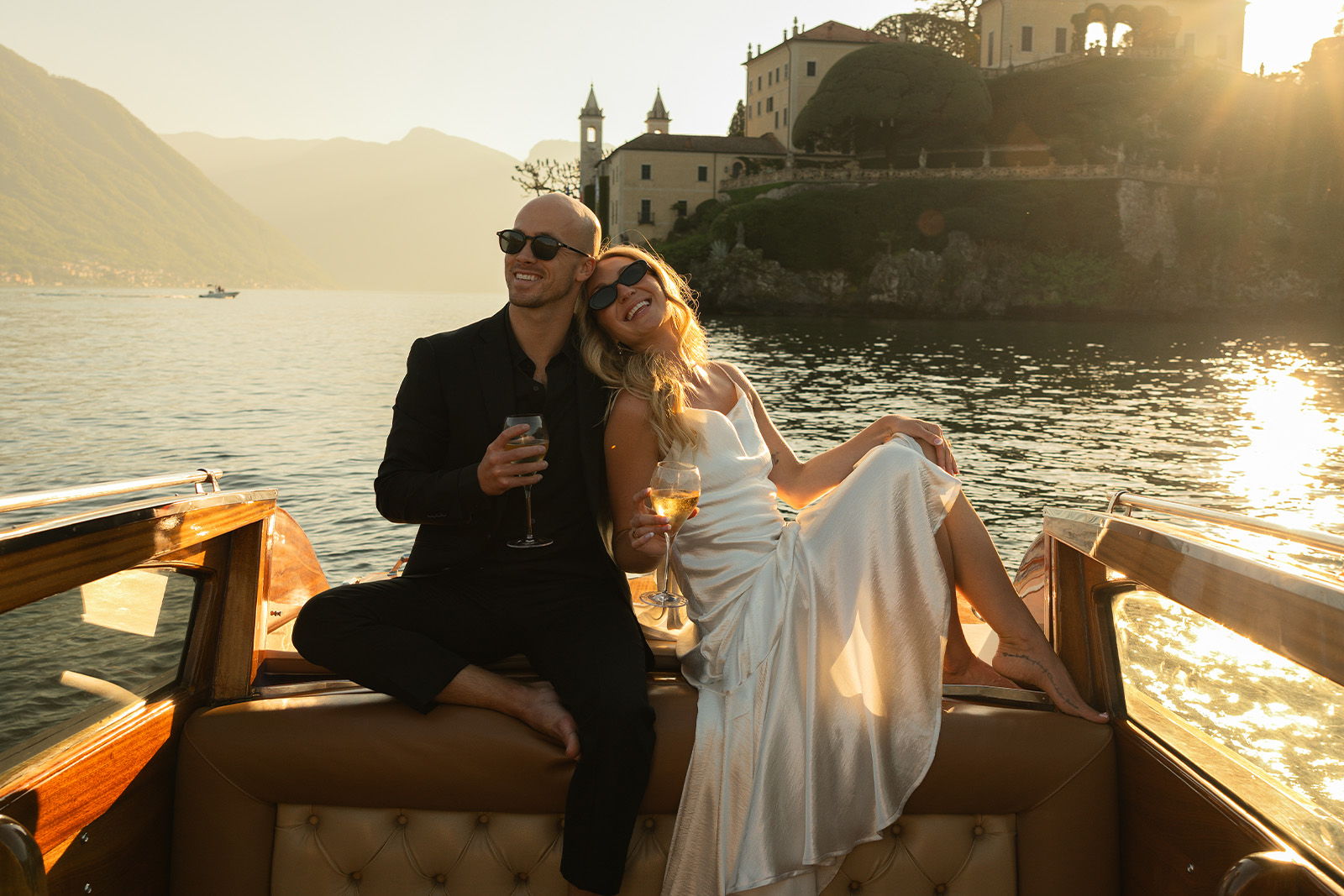 Couple enjoying a sunset on a boat by the water.