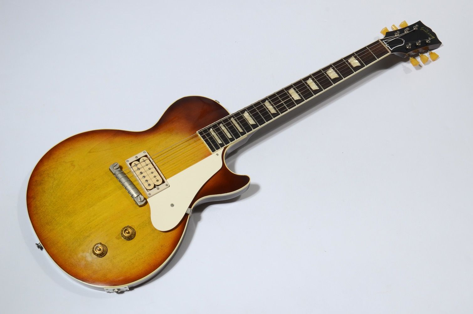 Electric guitar with a sunburst finish on a white background.