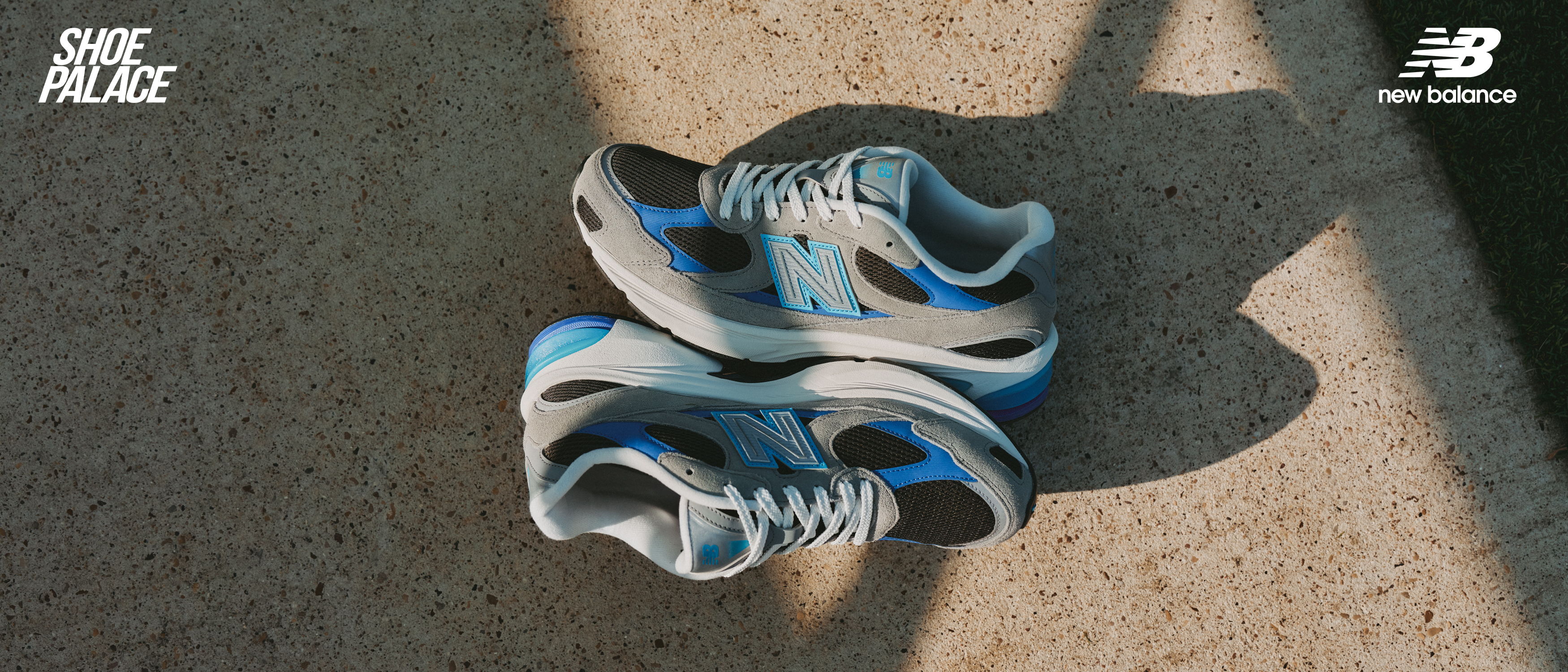 A pair of blue and gray running shoes on a concrete surface.