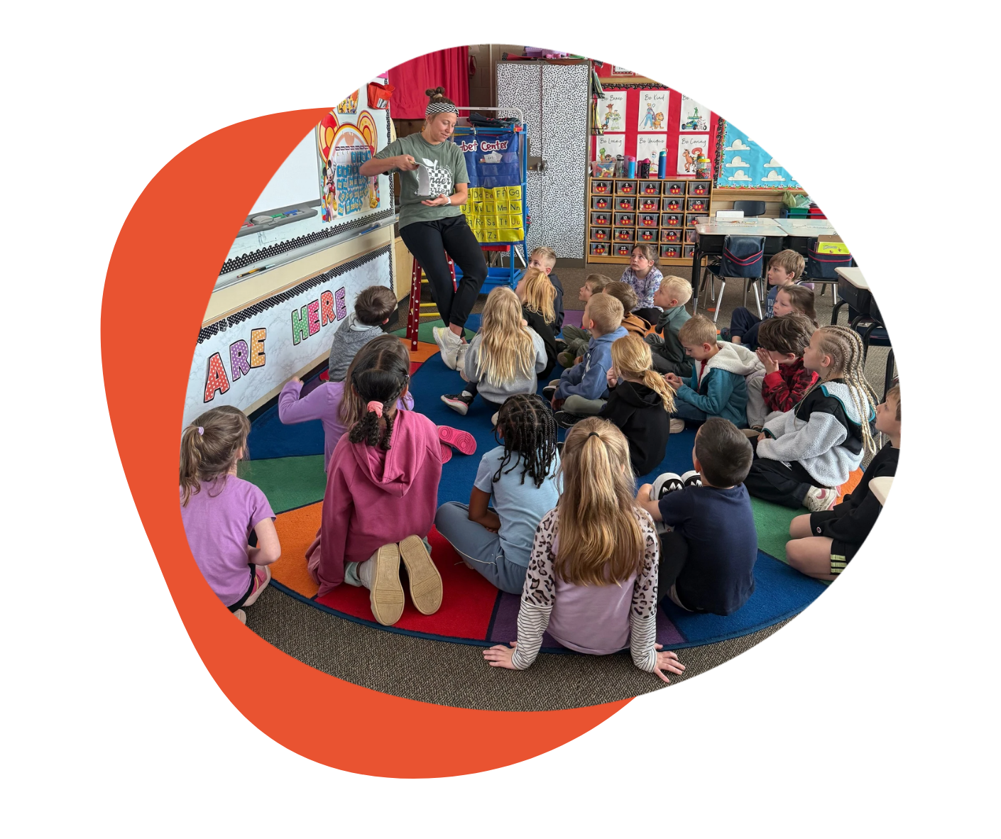 Teacher reading to a group of students in a classroom setting.
