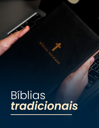 A person holding a traditional Bible over a laptop keyboard.