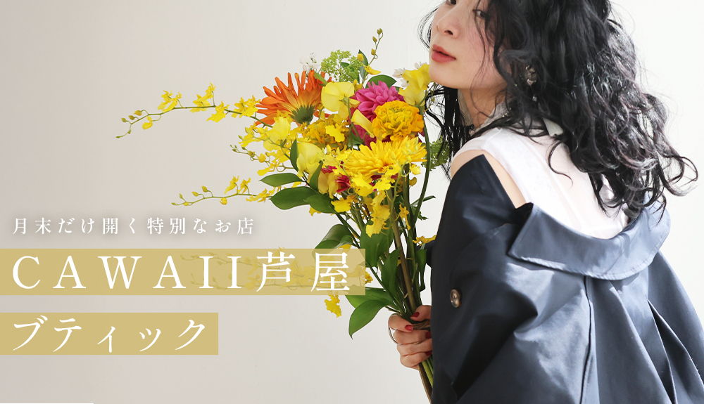 Person holding flowers, wearing a black outfit with a white collar.