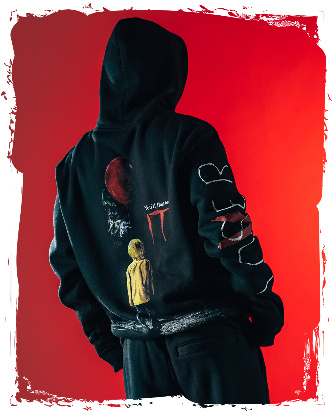 Person wearing a black hoodie with colorful graphics against a red background.