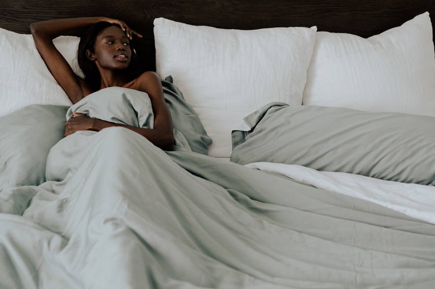 woman lying in bed covered by a bamboo duvet cover